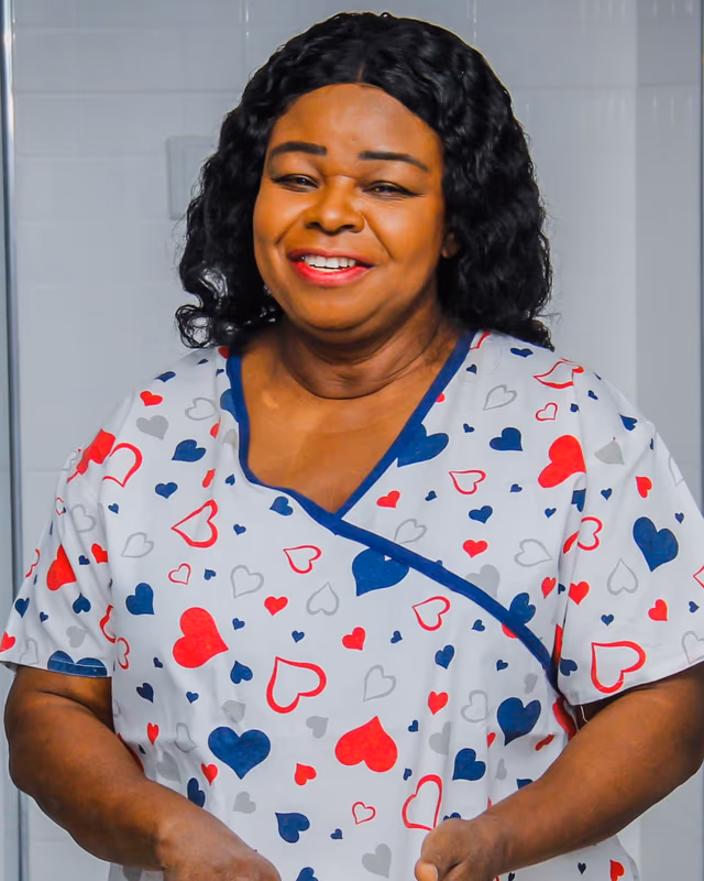 Illustrative scene: Dr. Beatrice Wiafe Addai smiling, in a white top printed with red and navy hearts.